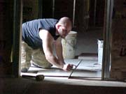 Christopher lays tile in the kitchen
